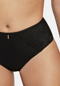 Zwart hoge taille slipjes van een gladde stof met kantdetails aan één kant en een klein metalen accent, met een golvende rand.