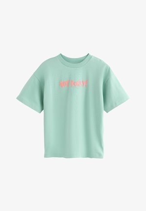 Tricou verde mentă cu mânecă scurtă, guler rotund și dungi, cu text roz "NOT SORRY!" imprimat în centru.