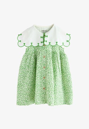 Grøn blomsterkjole med hvid bølget krave, der har grøn kant og små knapper ned foran. Fremstillet af let, mønstret stof.