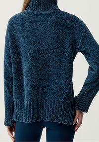 Mörkblå långärmad tröja med ribbad polokrage, med en något lös passform och texturerad stickad tyg. Ribbad nederkant och manschetter.