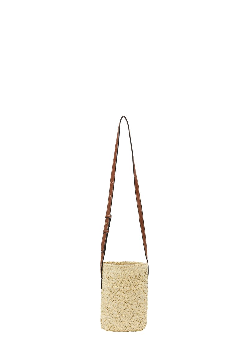 Woven straw crossbody bag in light beige with a brown adjustable leather strap. Cylindrical shape, textured surface, and open top design.