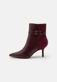 Burgundowe botki za kostkę z szpiczastym noskiem, 5 cm obcasem w szpilce, górą z dzielonej skóry i zamszu oraz paskiem z złotą prostokątną klamrą.