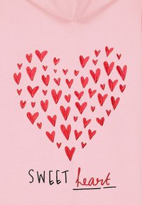 Sweat à capuche rose avec un cœur composé de divers cœurs rouges et le texte "SWEET heart" en noir et rouge. Tissu doux et design décontracté.