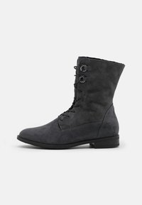 Bottine en cuir suédé gris avec bout arrondi, laçage à l'avant et surface texturée. Talon bas et design simple sans motifs distincts.