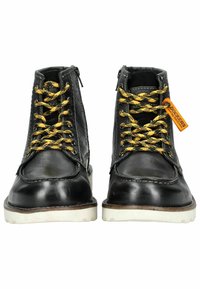 Botas de cuero negro con cordones amarillos estampados, cremallera lateral, suela de goma blanca y detalle de costura en marrón contrastante.