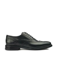 Black leather dress shoe with brogue detailing, featuring a smooth texture, lace-up closure, and a stacked heel. Classic design.