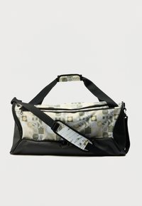 Μαύρη τσάντα duffel με γεωμετρικό ύφασμα σε πράσινο, κίτρινο και λευκό. Διαθέτει μαύρο λουράκι και επάνω λαβή για εύκολη μεταφορά.