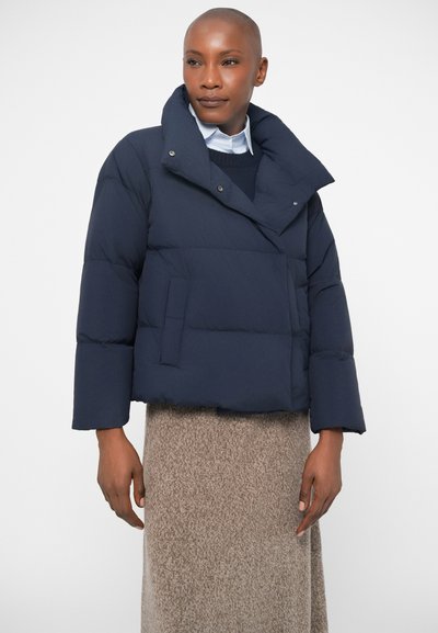 Tumepane sinine topp-jope, millel on kõrge kaelus ja mis on valmistatud tikitud kangast. Varustatud esise klõpsuga ja küljetaskuga, laiad varrukad.