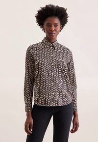 Langærmet skjorte med knapper i sort med beige blomsterprint, med skræddersyet krave og lommedetaljer, lavet af letvægtsstof.