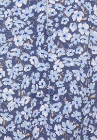 Tessuto a fantasia floreale in tonalità di blu e bianco, con uno sfondo blu scuro, impreziosito da piccoli bottoni in un colore coordinato.