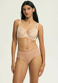 Beżowy biustonosz z ozdobną koronką, fiszbinami i regulowanymi ramiączkami, zestawiony z beżowymi majtkami z wysokim stanem i prążkowaną fakturą, gładka tekstura, minimalistyczny design.