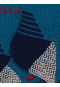 Calzini multicolori con base turchese, tallone e punta blu navy, motivi a zigzag e testo rosso. Maglia morbida con texture soffice e dettagli geometrici.