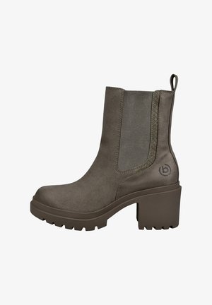 Khaki botki wykonane z miękkiego zamszu, z grubą, rowkowaną podeszwą oraz elastycznymi panelami po bokach i pętelką ułatwiającą zakładanie.