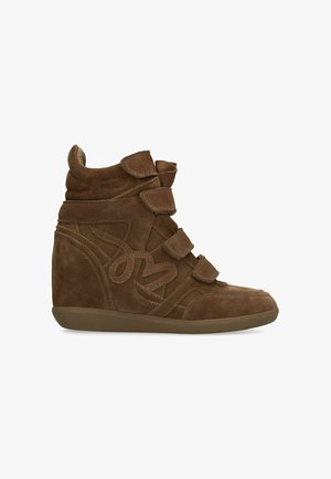 Brown suede wedge sneaker with three velcro straps and stitched decorative patterns on the side.