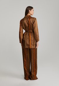 ANDIATA KARIE - Pantaloni - orange/brown