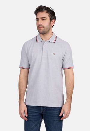 Polo gris à manches courtes, avec un col à rayures rouges et bleu marine et un logo brodé circulaire sur la poitrine.