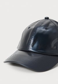 Casquette de baseball en bleu marine, brillante, avec une couronne arrondie, des panneaux cousus et une visière courbée. Elle dispose d'un bouton sur le dessus et de trous de ventilation.