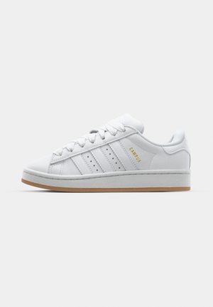 Witte sneaker met geperforeerd design met drie strepen, gestructureerde accenten, een rubberen zool en het "CAMPUS" logo in het goud aan de zijkant.
