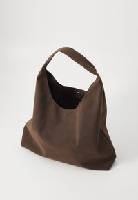 Smeđa kožna torba na rame s mekom teksturom, velikim otvorom i jednom ručkom. Ima kopču na tipku i minimalistički dizajn.