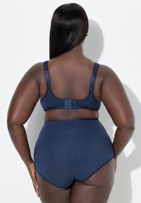 Laivastonsininen rintaliivisarja ja korkeavyötäröiset alushousut, joissa säädettävät olkaimet ja teksturoitu kuviointi alusvaatteissa, tehty pehmeästä, joustavasta kankaasta.