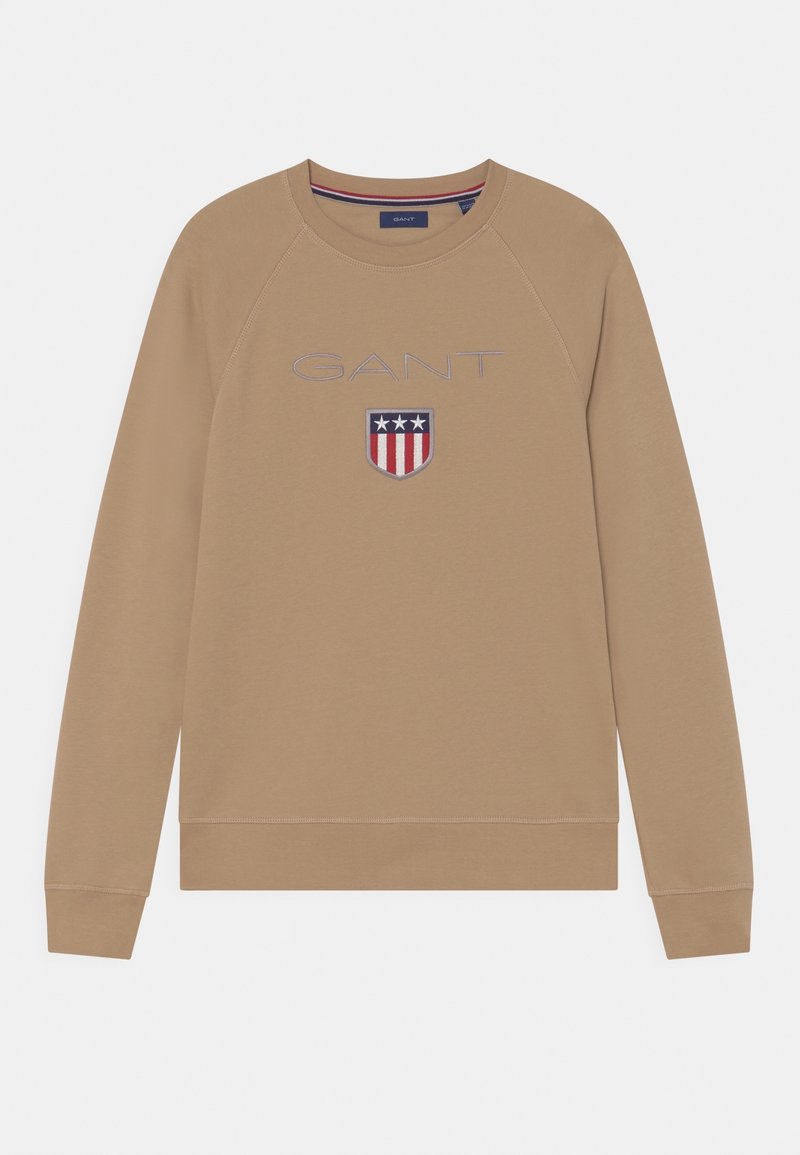 Beżowy sweatshirt z rękawami raglanowymi, z logo "GANT" i wzorem tarczy w czerwonych, białych i niebieskich akcentach. Wykonany z miękkiej bawełny.