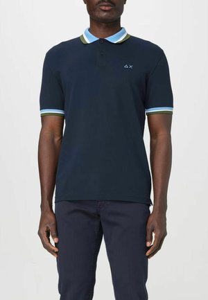 Polo shirt blu navy con colletto e bordi delle maniche in contrasto di azzurro chiaro e verde, con un piccolo logo sul petto. Tessuto morbido.