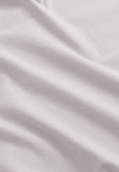 Tissu blanc lisse avec des plis doux et des ombres subtiles, montrant la texture et des rides légères.