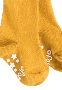 Calzini di cotone di colore giallo senape, con modelli di stelle e pois bianchi antiscivolo sulle suole, caratterizzati da una finitura morbida e testurizzata.