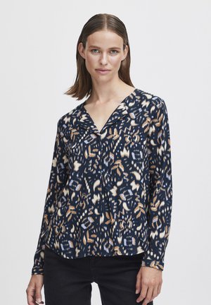 Blusa blu navy con un motivo astratto multicolore, maniche lunghe e colletto a V. Realizzata in tessuto leggero, presenta una consistenza morbida.