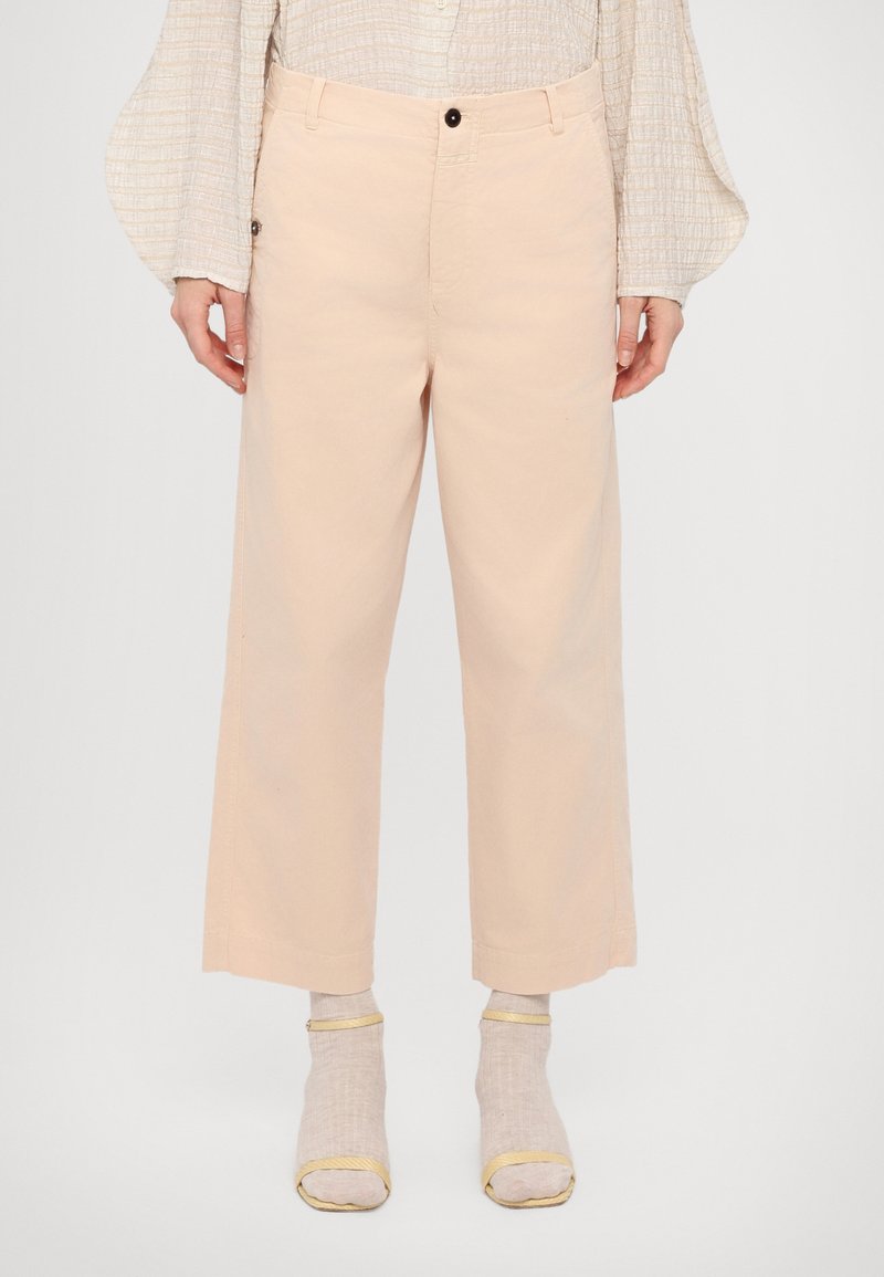 Pantaloni scurți roz pal, cu un design drept, care se închid cu un nasture și au o buzunar lateral și margini rulate. Material texturat.