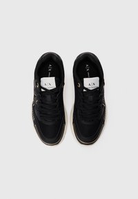 Pair of black Armani Exchange sneakers with mesh and leather details, white logo tags on tongues, and white soles on a plain background.