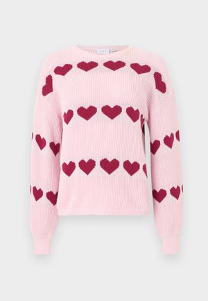 Ανοιχτό ροζ πλεκτό πουλόβερ με σειρές από σκούρα ροζ σχέδια καρδιών στο στήθος, τα μανίκια και τη μέση, με στρογγυλή λαιμόκοψη.