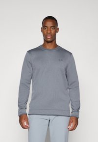 Gray long-sleeve sweatshirt with a textured fabric and round neckline. Features subtle branding on the chest and ribbed cuffs.