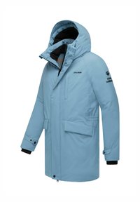 Svetlo modrá zateplená bunda s veľkou kapucňou, predným zipsom, dvoma bočnými vreckami a čiernou podšívkou. Na rukáve je umiestnené logo značky.