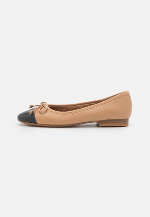 Beige læder ballet flad med sort rundt tåhæt og lille sløjfedetalje, flad sål og lav stablet hæl, sidevisning på hvid baggrund.