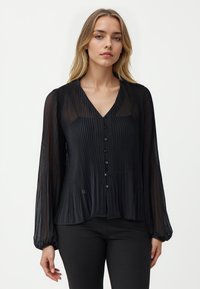 Schwarze, plissierte Bluse mit V-Ausschnitt, langen puffärmel und Knopfleiste. Hergestellt aus leichtem, durchsichtigem Stoff mit fließendem Design.