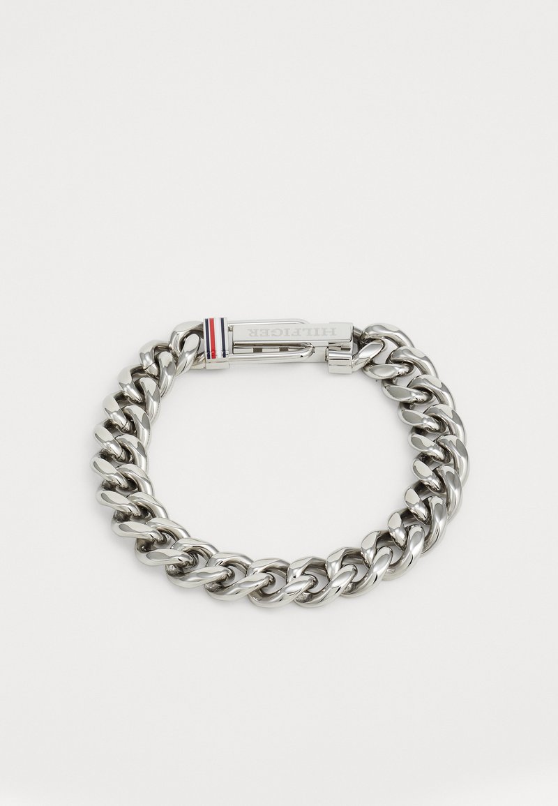 Zilveren metalen armband met grote in elkaar grijpende schakels. Bevat een sluiting met een klein rood, wit en blauw accent. Gepolijste afwerking.