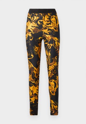 Leggings in a black fabric featuring a bold yellow baroque floral pattern. Waistband includes logo detailing. Form-fitting design.