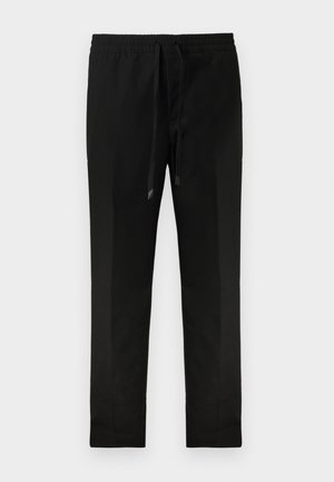 Pantalons noirs fuselés avec une taille élastique et un cordon de serrage. Tissu lisse, design minimal, sans poches visibles ni motifs.