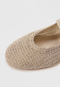 Ballerines en toile dorée avec un bout rond et un intérieur doux et lisse. La texture est finement détaillée avec un design en maillage respirant.