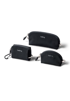 Trois pochettes zippées noires Bellroy de différentes tailles, dont une avec un clip, disposées sur un fond blanc.