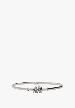 Silver bangle with three circular bead accents, two adorned with clear gemstones. Smooth texture, minimalist design, and oval shape.