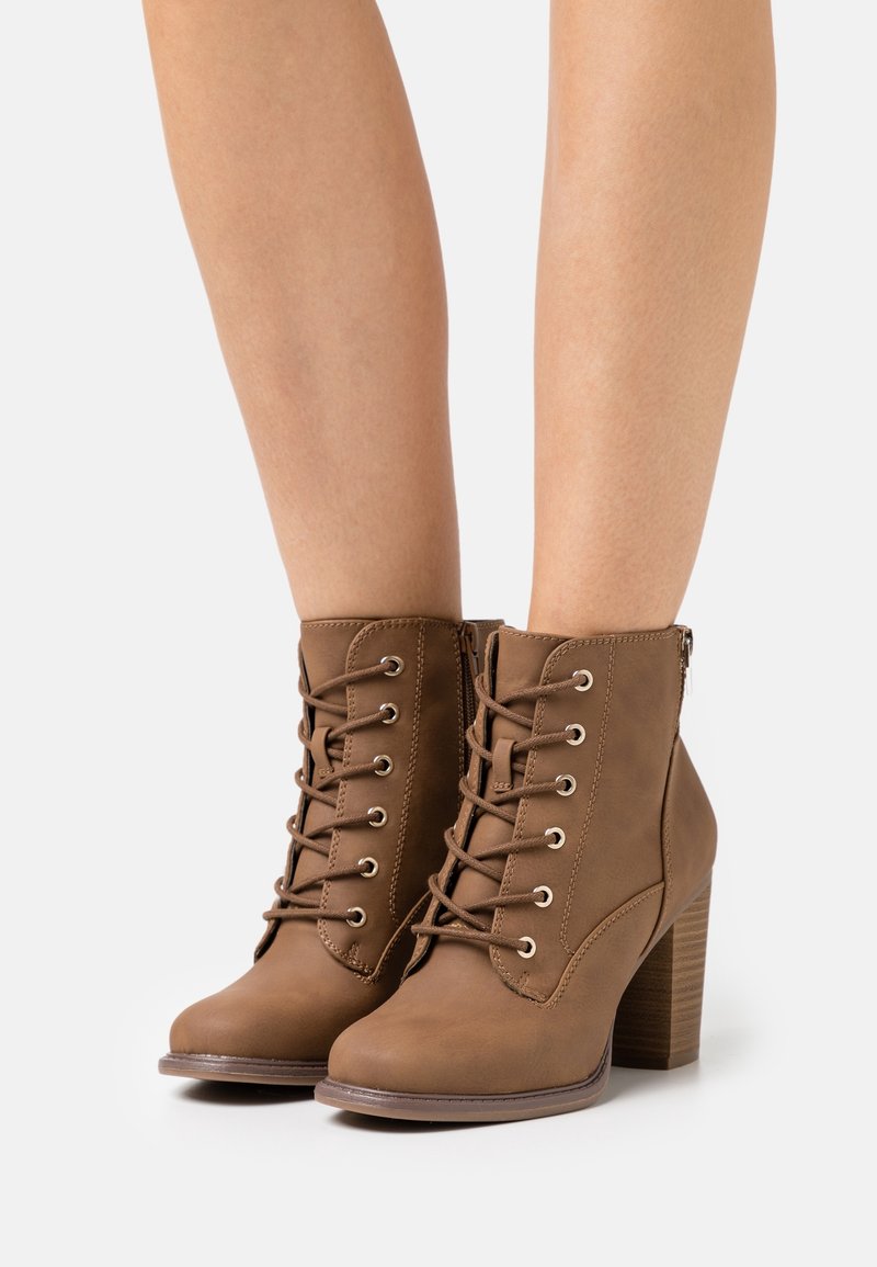 Brązowe ankle boots z imitacji skóry z sznurówką z przodu, metalowymi oczkami i teksturowanym obcasem, z bocznym zamkiem błyskawicznym dla łatwego zakupu.