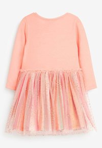 Pitkähihaisen vaaleanpunaisen puuvillamekon alaosa on useampitasoinen ja siinä on hohtavaa tylliä, jonka alareunassa on kullanvärisiä pilkkuja.