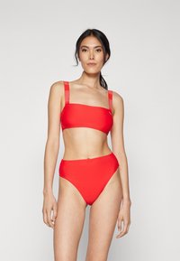 Rode bikini set met een rechthoekige bandeau-top en een hooggetailleerde onderkant. Beschikt over brede bandjes met logo-detail en een gladde, rekbare textuur.