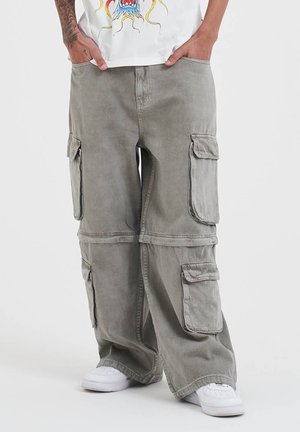 Cargo bukser i olivengrøn bomuld, med flere store sidelommer, en afslappet pasform og lige ben. Sammen med hvide sneakers.