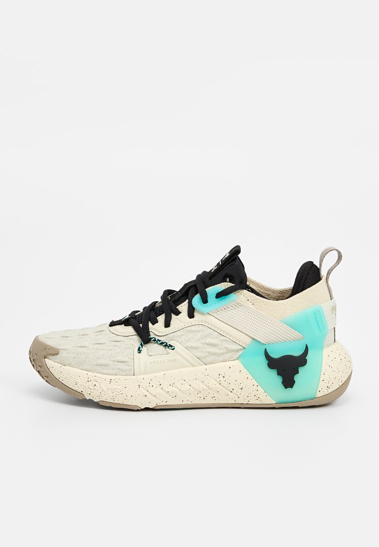 Chaussure de sport beige avec des accents noirs, dessus texturé, semelle mouchetée, détails turquoise et un logo de taureau noir sur le talon.