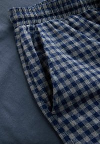 Cotton checkered fabric with a navy blue and gray pattern, featuring an elastic waistband and a soft, textured surface.