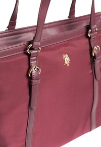 Bordo tote taška vyrobená z nylonu a syntetické kůže, s hardwarem ve zlatém odstínu a detaily loga. Hladký povrch s dvojitými uchy.