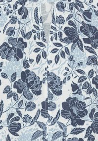 Weißer Stoff mit navyblauen und hellblauen Blumenmustern; mit großen Blüten, Blättern und einer kleinen Schlüssellochöffnung am Halsausschnitt.